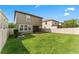Large grassy backyard area with a privacy fence and a covered patio visible on the rear of the home at 935 Terra Vista St, Brandon, FL 33511