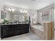 This primary bathroom features a double vanity, large mirror, soaking tub, and walk-in shower at 935 Terra Vista St, Brandon, FL 33511