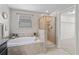 A primary bathroom showcases a large soaking tub, walk-in shower, and natural light at 935 Terra Vista St, Brandon, FL 33511
