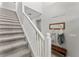 Carpeted staircase with white railing leading to the upper level; features a coat rack and bench at 935 Terra Vista St, Brandon, FL 33511