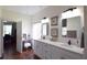 Bright bathroom with dual sinks, white cabinets, decorative mirrors, and access to the office at 10118 Cleghorn Dr, San Antonio, FL 33576