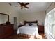 Bright bedroom featuring a large window, a ceiling fan, and comfortable bedding at 10118 Cleghorn Dr, San Antonio, FL 33576
