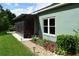 Exterior view of home featuring a screened patio, garden, and well maintained lawn at 10118 Cleghorn Dr, San Antonio, FL 33576