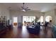 Spacious living room featuring dark hardwood floors, ceiling fan, and access to the patio at 10118 Cleghorn Dr, San Antonio, FL 33576