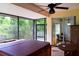 Screened patio with a hot tub, ceiling fan, sliding glass doors, and exterior views at 10118 Cleghorn Dr, San Antonio, FL 33576