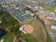 An aerial view captures the community baseball field and tennis courts, showing recreational amenities available to residents at 103 El Turco Ct, Sun City Center, FL 33573