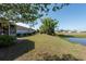 Expansive backyard featuring a pond, mature trees, and a well-maintained lawn, creating a serene outdoor space at 103 El Turco Ct, Sun City Center, FL 33573