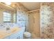 The bathroom is equipped with a toilet, sink and shower, all adorned with floral wallpaper at 103 El Turco Ct, Sun City Center, FL 33573