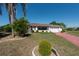Charming single-story home with a well-manicured lawn, mature landscaping, and a unique painted driveway at 103 El Turco Ct, Sun City Center, FL 33573
