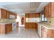 This eat-in kitchen is equipped with wood cabinets, tiled floor, laminate countertops and modern appliances at 103 El Turco Ct, Sun City Center, FL 33573