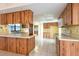 Well-lit kitchen featuring wood cabinets, ample counter space, and tile flooring at 103 El Turco Ct, Sun City Center, FL 33573