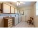 Bright laundry room with ample cabinet space, tiled flooring, and washer/dryer hookups at 103 El Turco Ct, Sun City Center, FL 33573