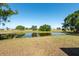Picturesque pond view framed by mature trees and a sprawling green lawn, offering a serene and natural backdrop at 103 El Turco Ct, Sun City Center, FL 33573