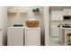 Laundry room with washer, dryer, shelving, and view of kitchen, blending functionality with style at 103 Leisure Pl, Rotonda West, FL 33947