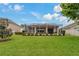Expansive screened-in patio overlooking a well-maintained yard with lush landscaping, ideal for outdoor entertaining at 10734 Breaking Rocks Dr, Tampa, FL 33647