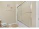 Bathroom featuring enclosed shower-tub combo with tiled walls and sliding glass doors at 10734 Breaking Rocks Dr, Tampa, FL 33647