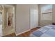 Bedroom view showcasing closet, window, and hardwood floors leading to hallway at 10734 Breaking Rocks Dr, Tampa, FL 33647