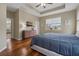 Well-lit bedroom with wood floors, a ceiling fan, and a view into another room at 10734 Breaking Rocks Dr, Tampa, FL 33647