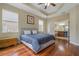 Bedroom with hardwood flooring, a tray ceiling and an ensuite bathroom at 10734 Breaking Rocks Dr, Tampa, FL 33647