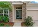 Close up of front door with sidelight and stone facade at 10734 Breaking Rocks Dr, Tampa, FL 33647