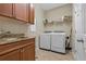 Laundry room with front-load washer/dryer, cabinets, granite countertops, sink, and storage, providing convenience at 10734 Breaking Rocks Dr, Tampa, FL 33647