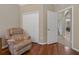 Living room featuring hardwood floors, comfortable recliner and open doorway at 10734 Breaking Rocks Dr, Tampa, FL 33647