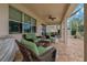 Covered outdoor patio with wicker furniture, ceiling fan, and brick-paved floors provides a comfortable space for relaxation at 10734 Breaking Rocks Dr, Tampa, FL 33647
