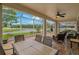 Screened-in patio with views of the lake and an outdoor dining set creating a scenic space for relaxing and entertaining at 10734 Breaking Rocks Dr, Tampa, FL 33647