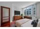 Bright bedroom with large window, wood floors, dresser and large screen television at 111 N 12Th St # 1614, Tampa, FL 33602