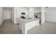 Open kitchen with white cabinets, island, stainless appliances, and tile flooring at 115 Leisure Pl, Rotonda West, FL 33947