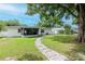 Lush backyard featuring a charming stone pathway and a tranquil screened lanai, ideal for relaxation at 125 Siobhan Ave, Tampa, FL 33613