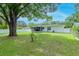 Expansive backyard with mature trees, fenced perimeter, and screened lanai, perfect for outdoor living at 125 Siobhan Ave, Tampa, FL 33613