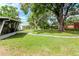 Well-maintained backyard with a stone path leading to a screened porch, offering serene outdoor space at 125 Siobhan Ave, Tampa, FL 33613