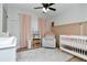 Cozy Bedroom with crib, changing table, glider, and pink curtains at 125 Siobhan Ave, Tampa, FL 33613