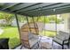 Screened-in porch with vaulted ceilings, egg chair, hammock, backyard and patio seating at 125 Siobhan Ave, Tampa, FL 33613
