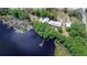 Aerial view showcases the home, wooded lot, private dock, and direct access to the lake at 13329 N Armenia Ave, Tampa, FL 33613