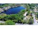 Overhead view features a lakefront property with a private dock, mature trees, and neighborhood views at 13329 N Armenia Ave, Tampa, FL 33613
