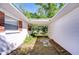Covered walkway featuring clean white walls with brick accents, connecting two parts of the home at 13329 N Armenia Ave, Tampa, FL 33613