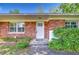 Charming brick home entrance with a white door and lush greenery, welcoming visitors with curb appeal at 13329 N Armenia Ave, Tampa, FL 33613