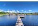 Scenic view of the lake and waterfront homes from the end of the wooden dock on a sunny day at 13329 N Armenia Ave, Tampa, FL 33613