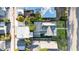 An aerial view shows a home with a lush green lawn, and a quaint brick patio shaded by palm trees at 136 30Th N Ave, St Petersburg, FL 33704