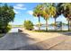 A concrete boat ramp provides access to the water, framed by mature palm trees and blue skies at 136 30Th N Ave, St Petersburg, FL 33704