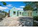 Charming teal exterior with a stone patio and yellow door in a sunny setting at 136 30Th N Ave, St Petersburg, FL 33704