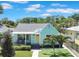 Charming single-story home featuring a cozy front porch, light teal siding and manicured lawn at 136 30Th N Ave, St Petersburg, FL 33704