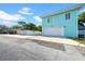 Exterior garage view features light teal siding and a large parking pad and driveway at 136 30Th N Ave, St Petersburg, FL 33704