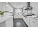 Bright white kitchen featuring stainless steel appliances, white cabinets, and dark hardwood floors at 136 30Th N Ave, St Petersburg, FL 33704