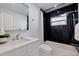 Modern bathroom with black marble shower surround, and white vanity at 145 174Th Terrace E Dr, Redington Shores, FL 33708
