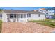 Charming home featuring a brick driveway, covered entry, and manicured lawn at 145 174Th Terrace E Dr, Redington Shores, FL 33708