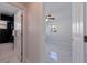 Hallway leading to an updated bathroom and bedroom with modern lighting and finishes at 145 174Th Terrace E Dr, Redington Shores, FL 33708