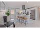 A modern kitchen with island seating, stainless steel appliances, and a view of the nearby dining area at 145 174Th Terrace E Dr, Redington Shores, FL 33708